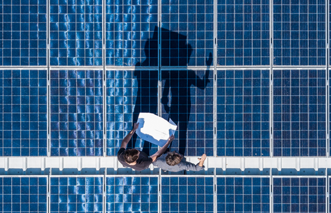 Zwei Menschen auf einem Dach, mit einer Solaranlage